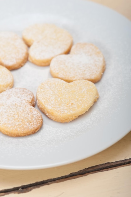 Photo high angle view of heart shape cookies in plate on table