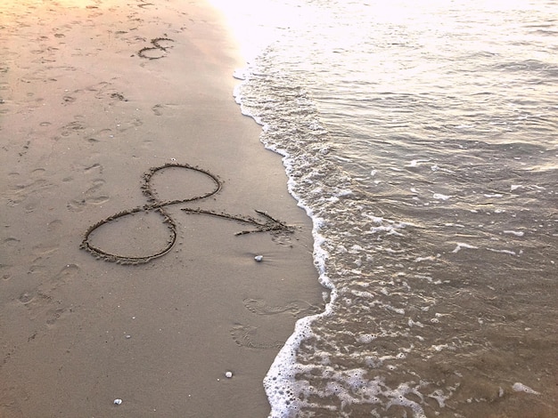 Foto vista ad alta angolazione della forma di un cuore sulla sabbia della spiaggia
