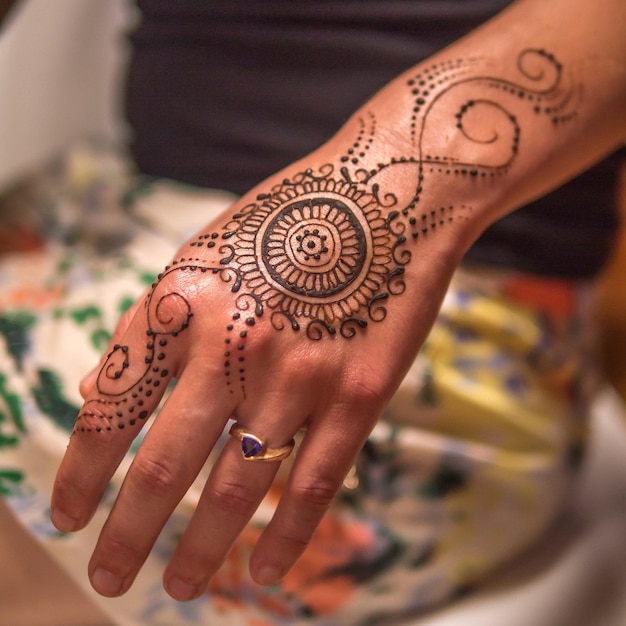 Foto vista ad alta angolazione del tatuaggio di henna sulle mani della donna