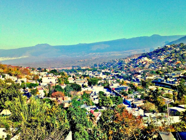 High angle view of houses in town against clear sky