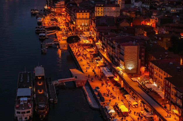 Photo high angle view of illuminated buildings by douro river at night in porto