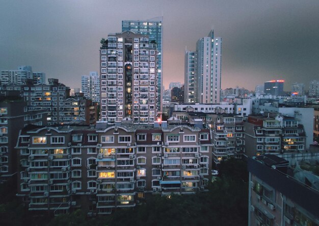 High angle view of illuminated buildings in city against skynight