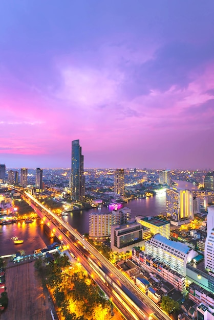 High angle view of illuminated city against sky at dusk