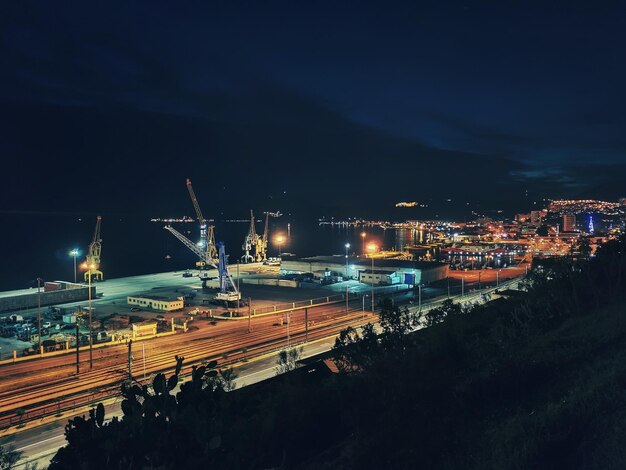 High angle view of illuminated city against sky at night