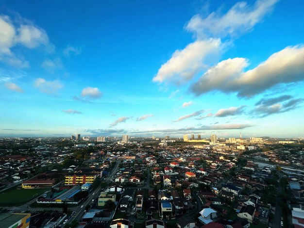 High angle view of illuminated city buildings against blue sky