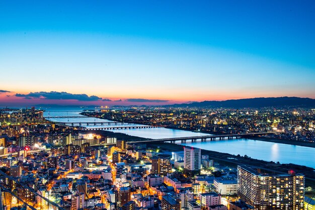 High angle view of illuminated city by river at night