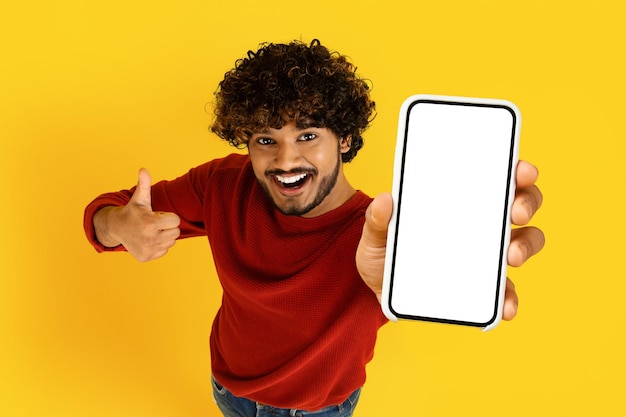 High angle view indian guy showing phone with white screen