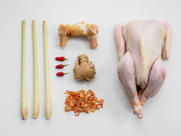 High angle view of ingredients for a thai chicken broth against white background