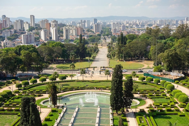 high angle view of Ipiranga Museum garden and fountains with Sao Paulo cityscape as backdrop, Brazil