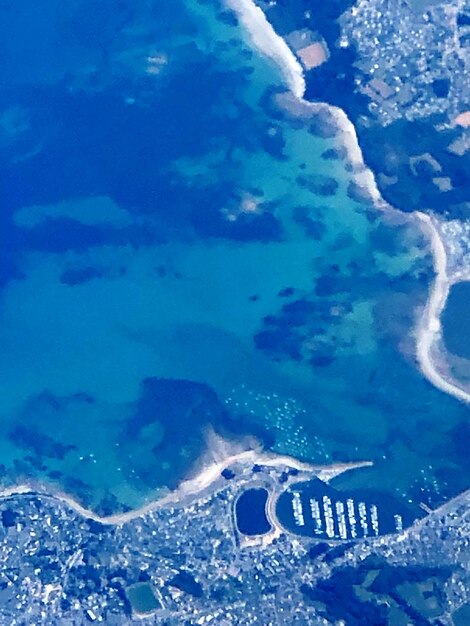 High angle view of island amidst sea against blue sky