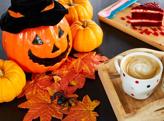 High angle view of jack o lantern with food and autumn leaves on table