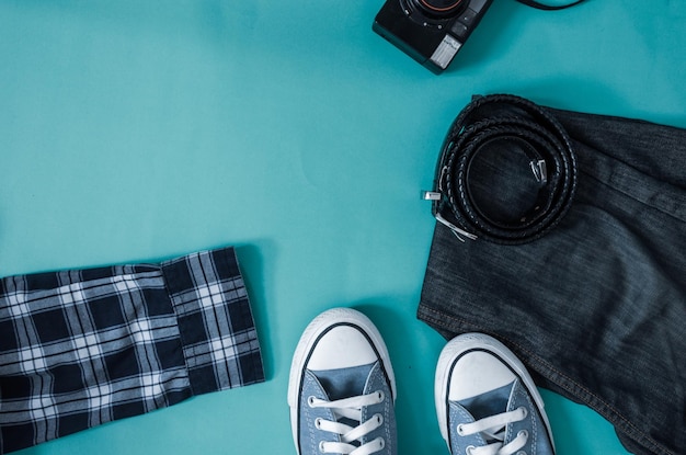 Photo high angle view of jeans with belt and shoes on table