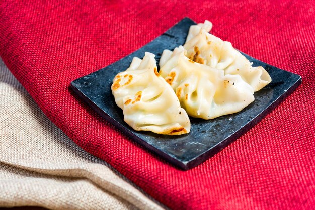 Foto vista ad alta angolazione di jiaozi in piatto su tavolo