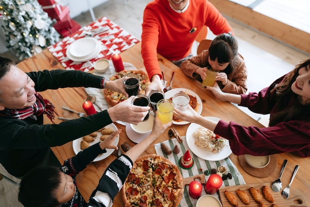 Photo high angle view of joyful asian multi generation family celebrates christmas and spending time together enjoying christmas party and having a celebratory toast over dining table at home