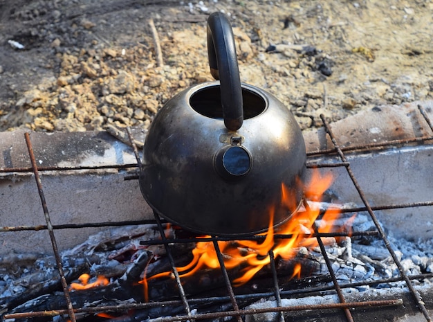 Foto vista ad alto angolo del bollitore sopra il fuoco nel campo