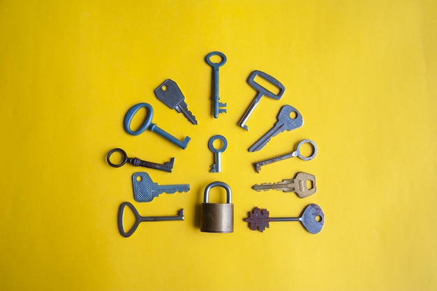 High angle view of keys and padlock on yellow background
