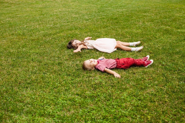 草の上に横たわっている子供たちの高角度の景色