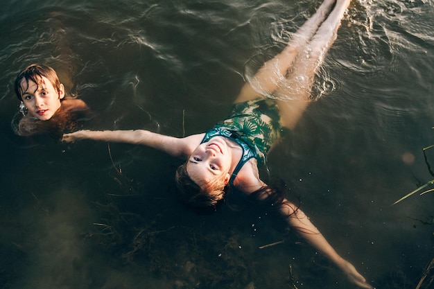 Высокоугольный вид детей, плавающих в озере