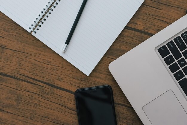 High angle view of laptop with mobile phone and book on table