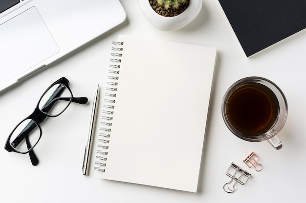 High angle view of laptop with office supplies and coffee on white background