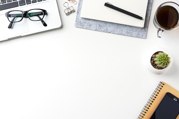 high angle view of laptop with office supplies and coffee on white background