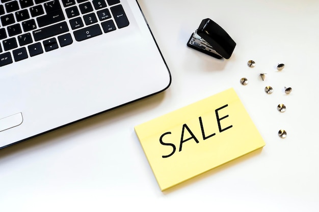 High angle view of laptop with sale text and stapler on table