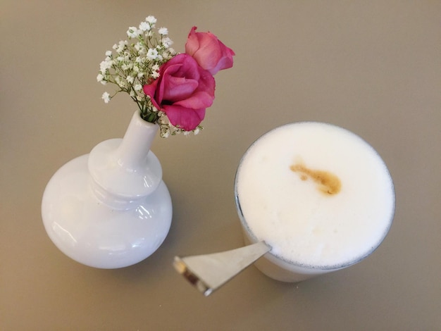 Foto vista ad alta angolazione del latte macchiato da un vaso di fiori sul tavolo