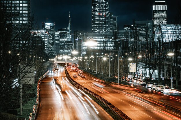 Foto vista ad alta angolazione delle tracce di luce sulla strada tra i grattacieli di notte