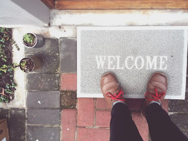 Photo high angle view low section of man standing on doormat