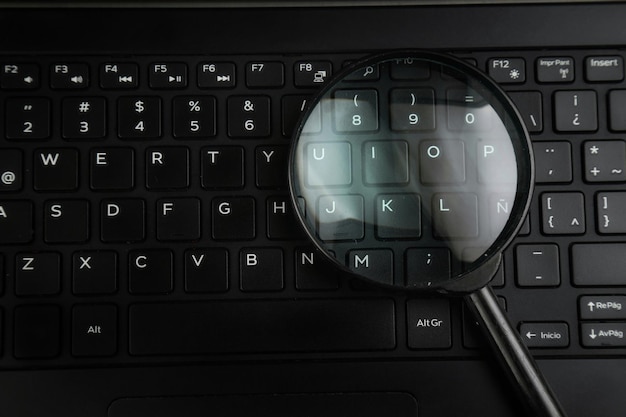 high angle view of magnifying glass on laptop keyboard