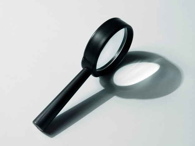 High angle view of magnifying glass on white background