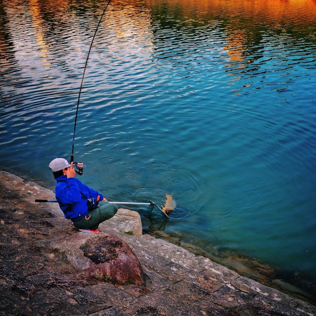 high angle view of man fishing at riverbank