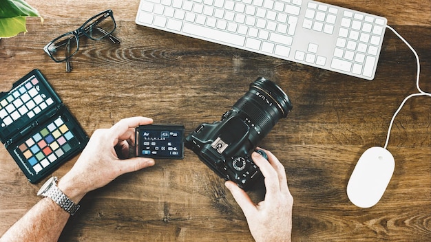 Photo high angle view of man holding camera at table