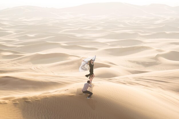 Photo high angle view of man photographing woman at desert