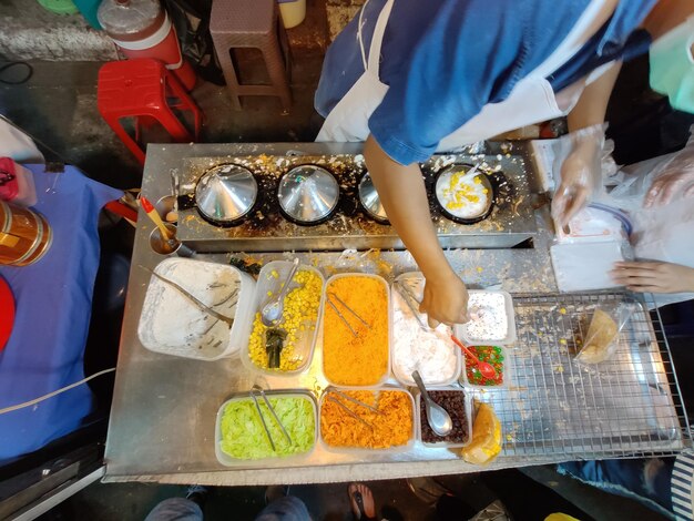 Photo high angle view of man preparing food at market stall