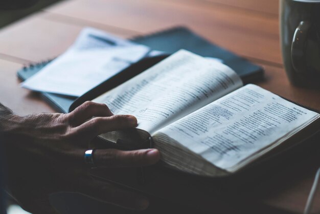 Photo high angle view of man reading book on table