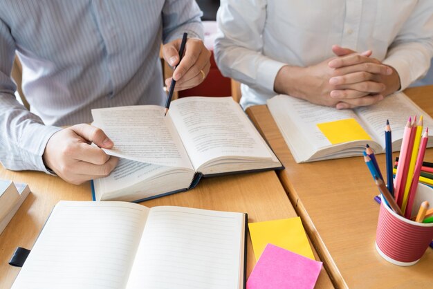 Foto vista ad alta angolazione di un uomo che legge un libro sul tavolo