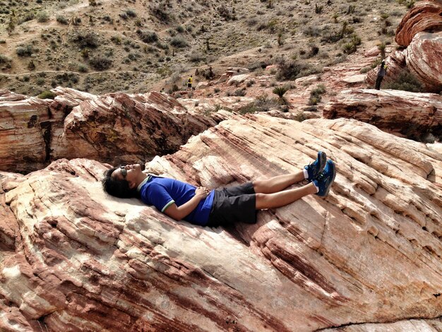 Photo high angle view of man relaxing on rock formation