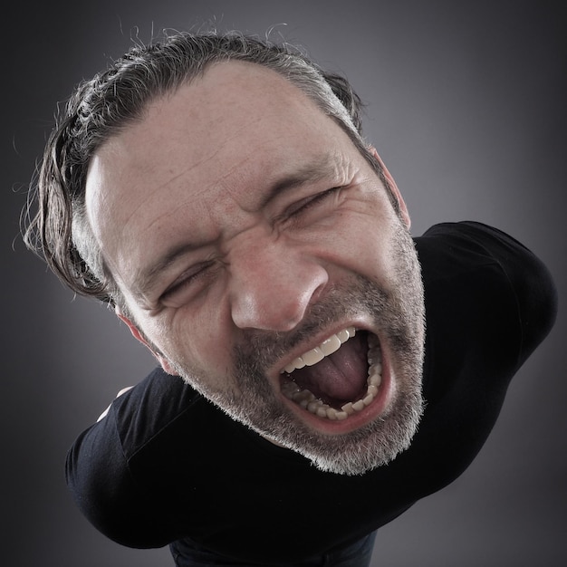 High angle view of man screaming against black background