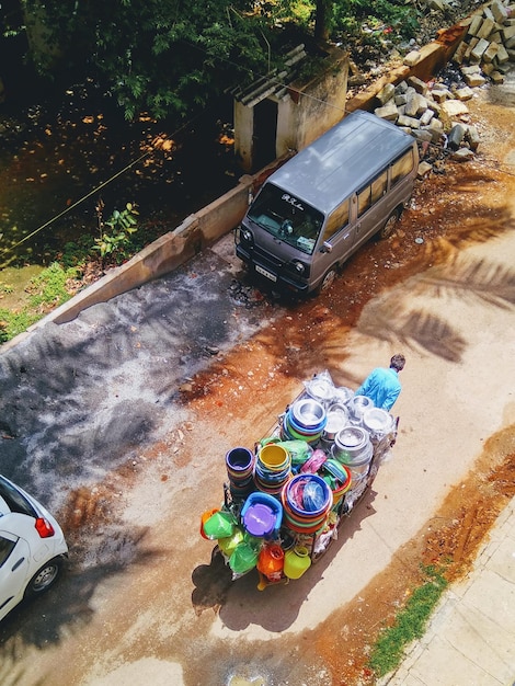 Foto vista ad alta angolazione di un uomo che vende contenitori su un carrello al mercato