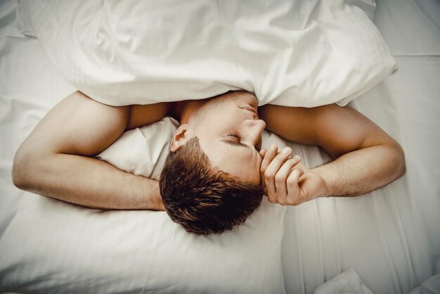 Foto vista ad alta angolazione di un uomo che dorme sul letto a casa