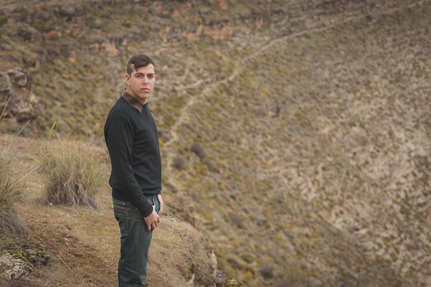 Photo high angle view of man standing on hill with hands in pockets