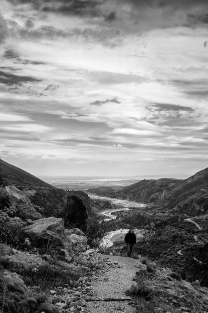 Photo high angle view of man standing on mountain against cloudy sky