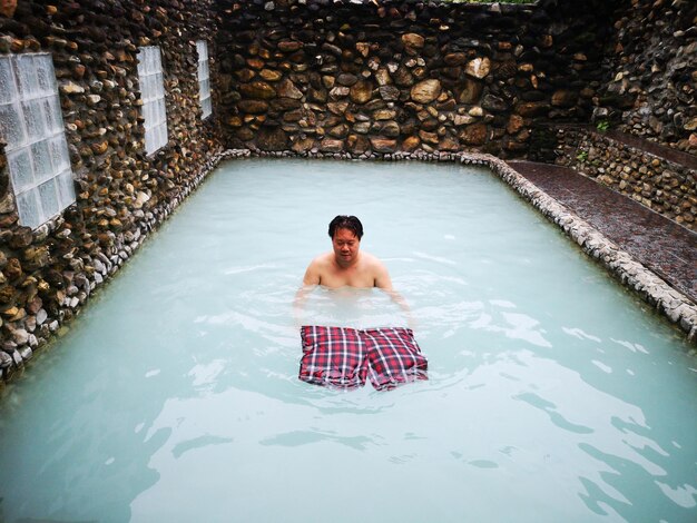 Foto vista ad alta angolazione di un uomo che nuota in piscina