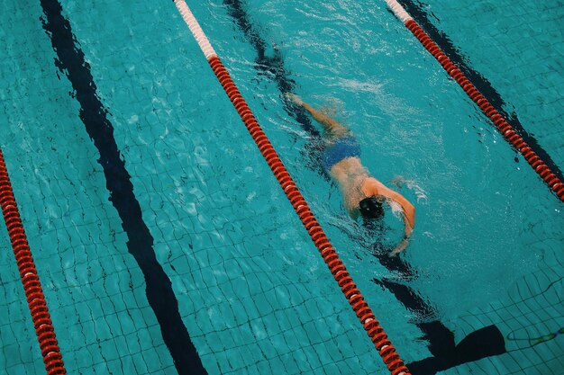 Foto vista ad alta angolazione di un uomo che nuota in piscina