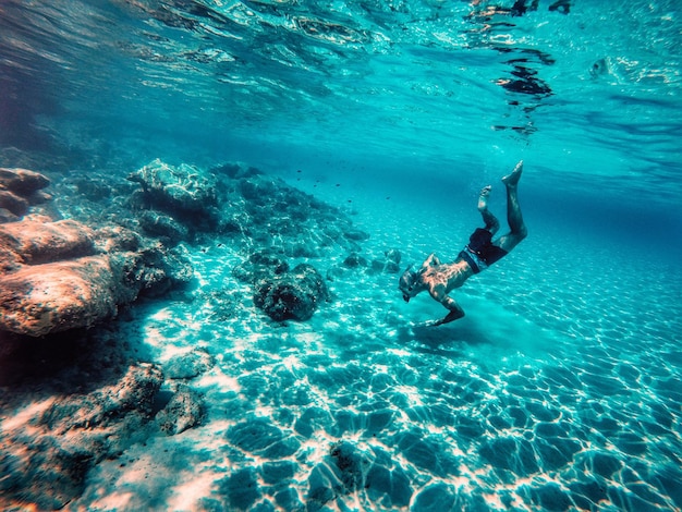 Foto vista ad alta angolazione di un uomo che nuota in mare