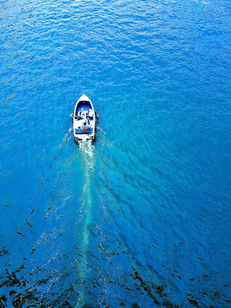 Foto vista ad alta angolazione di un uomo che nuota su una barca in mare