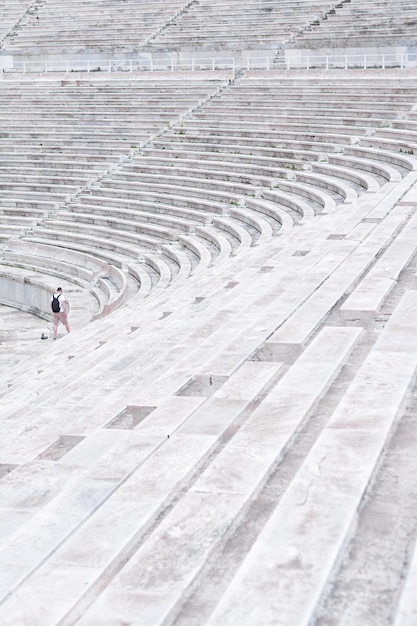 Foto vista ad alta angolazione di un uomo che cammina sui gradini dell'anfiteatro