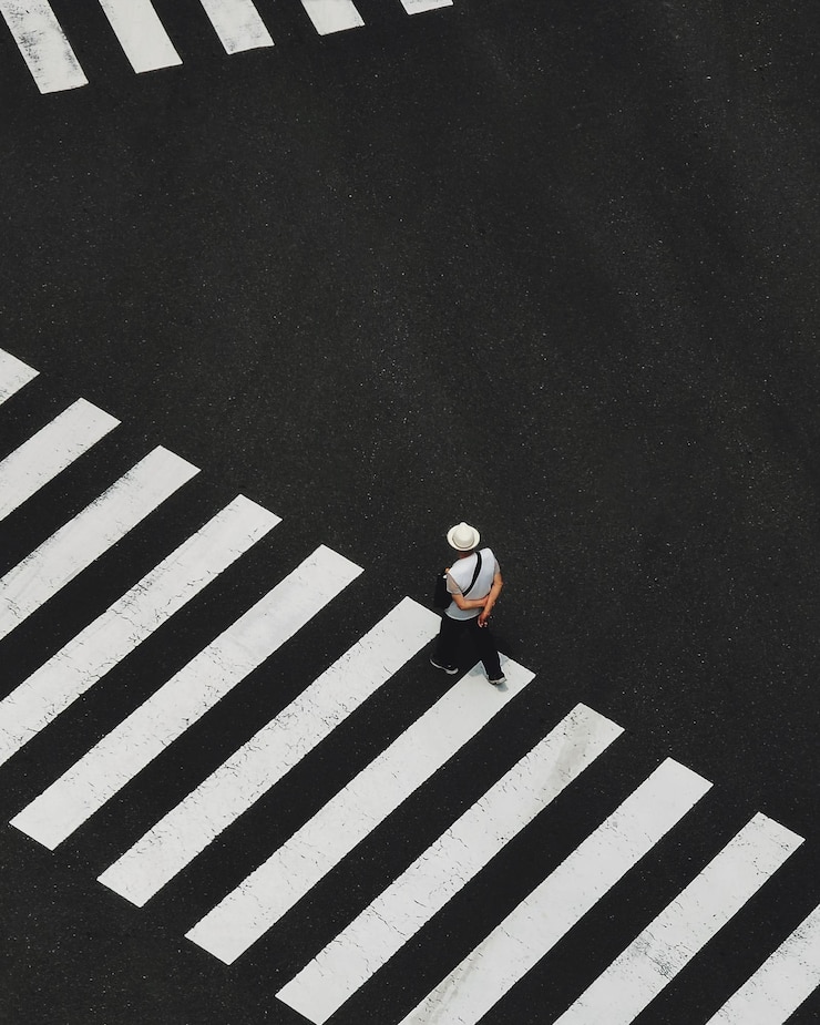 Photo high angle view of man walking on zebra crossing at street