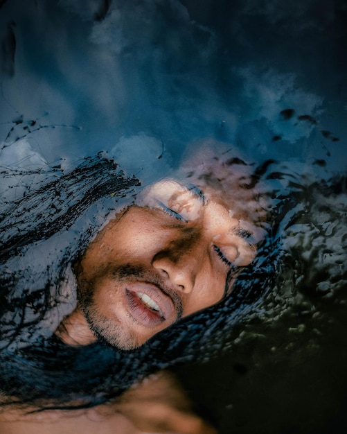 Foto vista ad alto angolo di un uomo con gli occhi chiusi in acqua